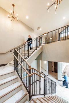 This image of the staircase and lobby detail at Collective Health shows a bright staircase, black railing, chandelier lighting, and clean entry finishes.