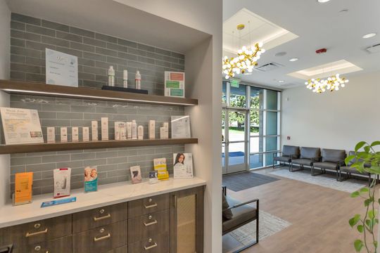 A retail product display at Elevation Dermatology shown beside the bright waiting area with modern seating and natural light.