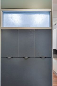 A close-up interior detail at Bridge Creek Dentistry showing dark textured storage cabinets, frosted glass transom, clean wall finishes, and modern dental office design.