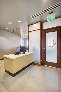 This image of the interior entry reception view at Meridian Periodontics of Central Park shows glass entry door, small reception counter, branded door graphic, and clean lobby flooring.