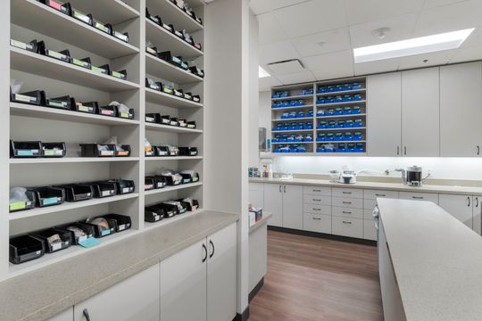 An organized dental supply room at Bridge Creek Dentistry featuring open shelving, labeled storage, cabinetry, work counters, and efficient clinical inventory space.