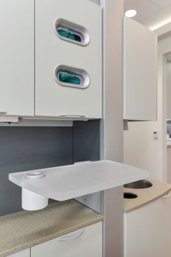 A close-up of a clinical storage station at Bridge Creek Dentistry featuring glove storage, white cabinetry, counter space, and streamlined dental operatory organization.