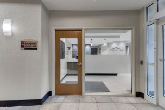 This image of the office entry vestibule at Soult and Swanson Family Dentistry shows glass entry doors, interior reception view, tiled floor, and clean dental office entry.