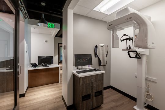 This image of the imaging alcove and hallway at Chroma Dental Studio shows dental imaging equipment, cabinetry, hallway access, overhead lights, and modern clinical finishes.