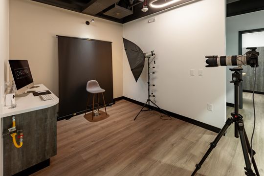 This image of the photography and imaging room at Chroma Dental Studio shows camera equipment, backdrop, patient stool, dental imaging tools, and wood flooring.