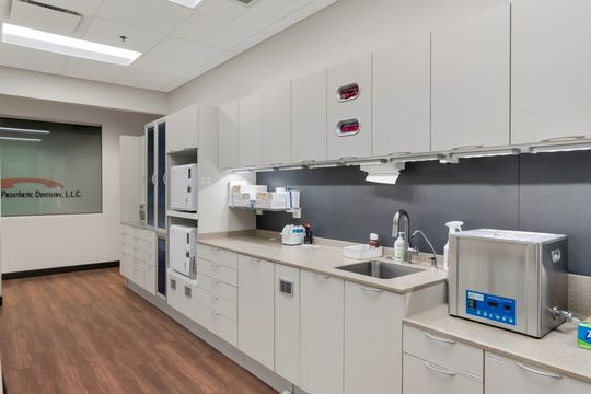 A clean sterilization and lab area at Bridge Creek Dentistry with white cabinetry, counter space, sink stations, dental equipment, and organized clinical workflow design.